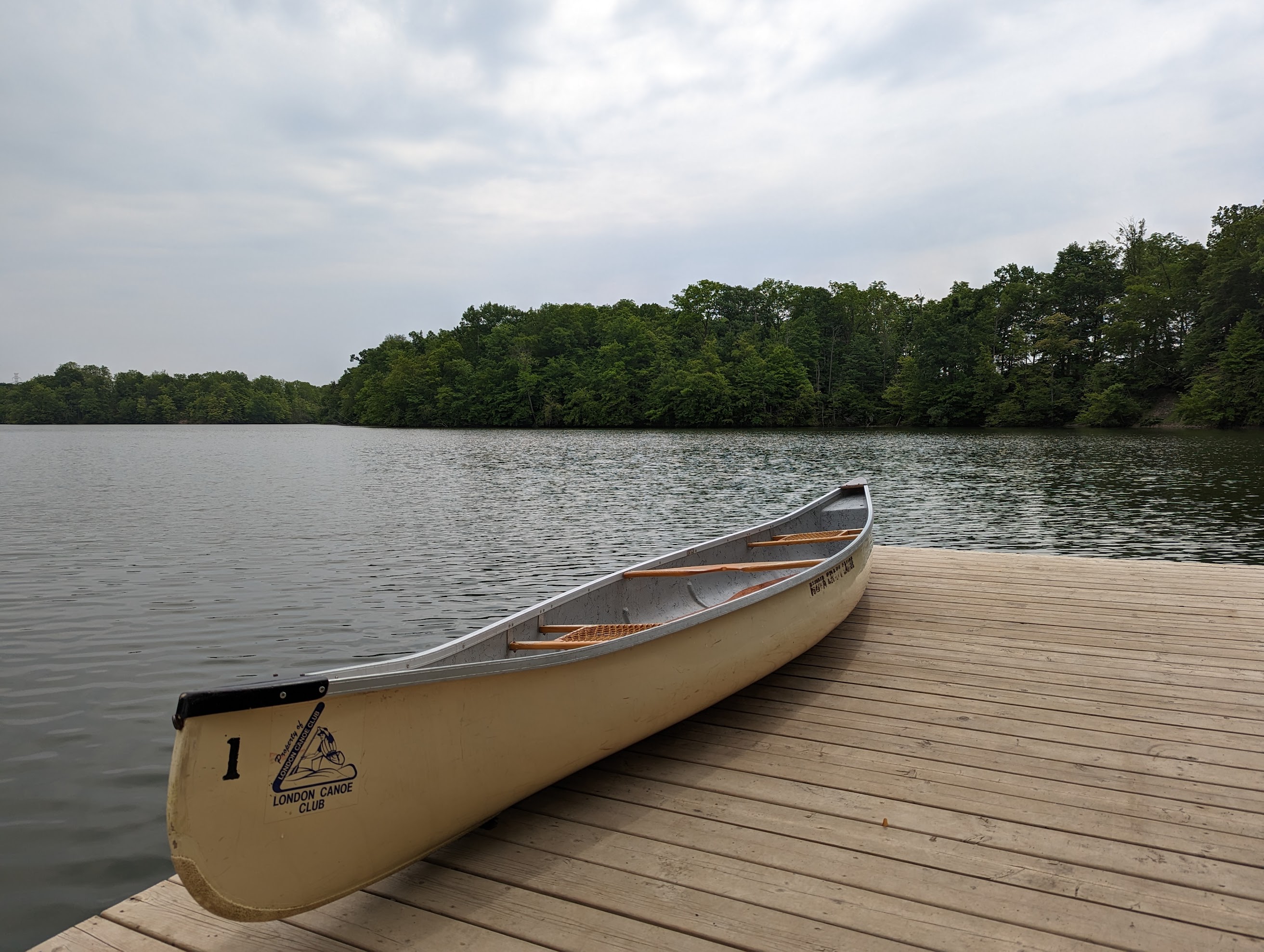 A Canoe Club canoe sitting on the dock at Sharon Creek Conservation Area
